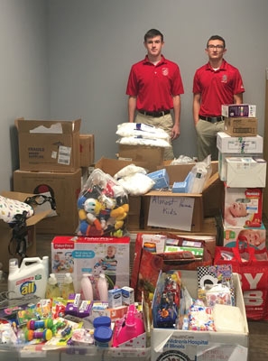 Two volunteers standing with donations at Almost Home Kids fundraiser
