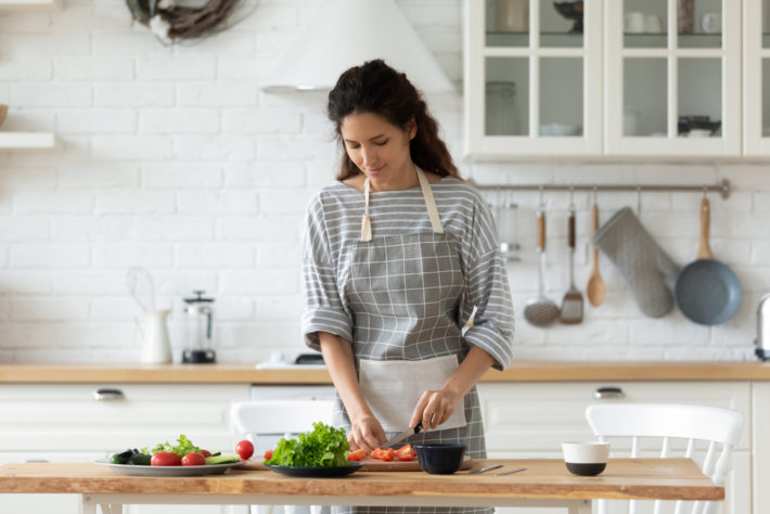Millennial,Woman,In,Apron,Stand,At,Kitchen,Table,Chop,Vegetables | OSF ...