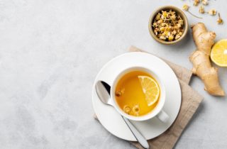 cup of tea on table with ginger and lemon.