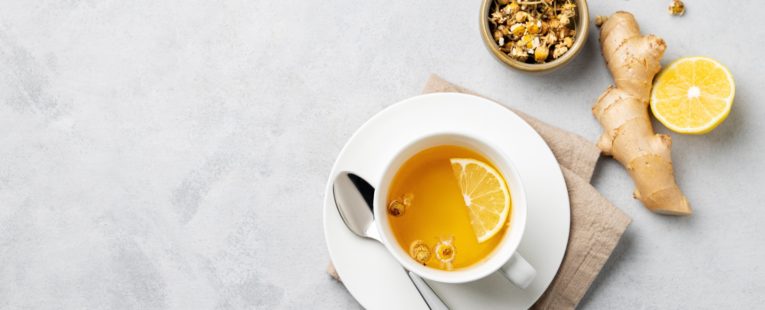 cup of tea on table with ginger and lemon.