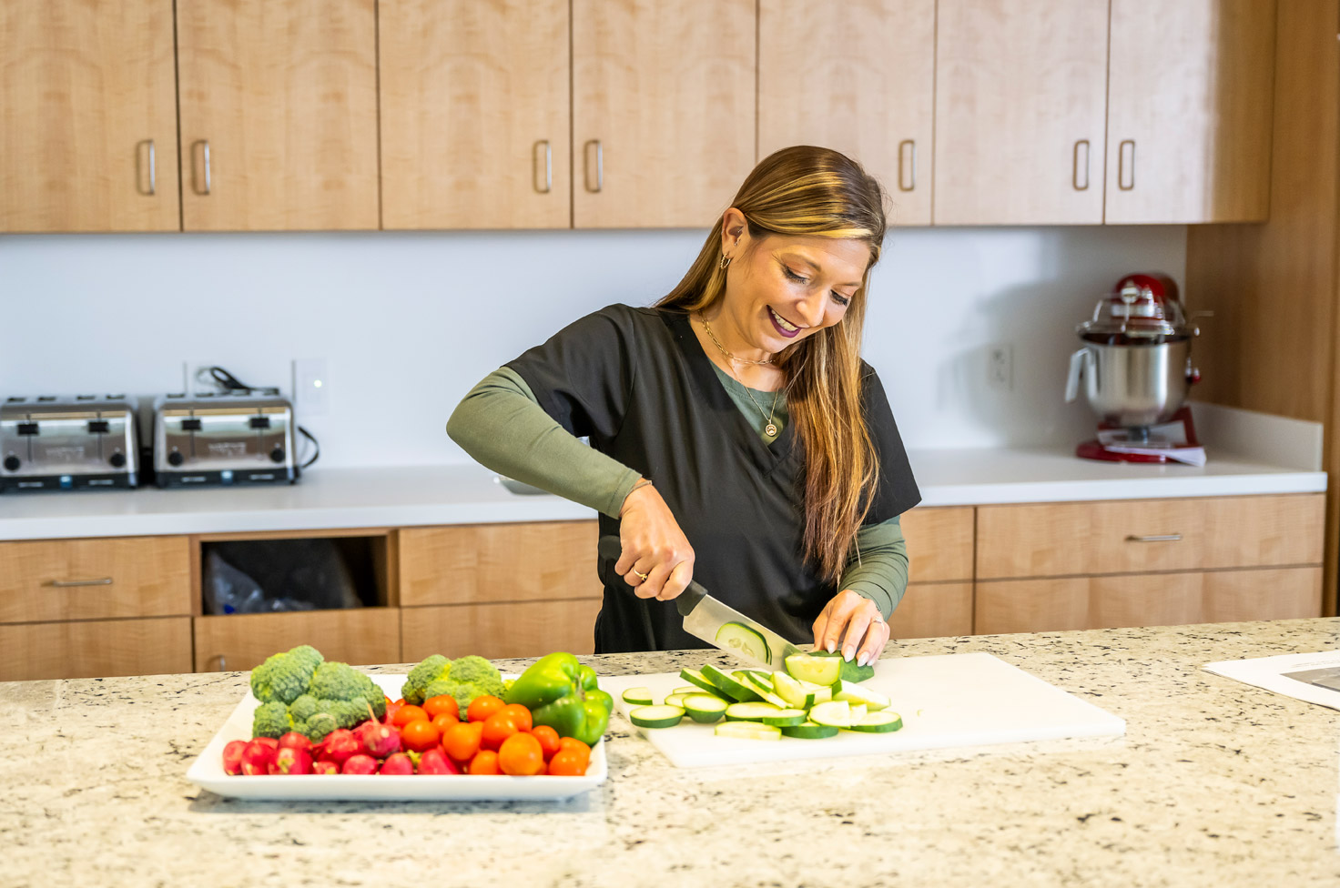 Image of a female dietician slice vegtables for a salad