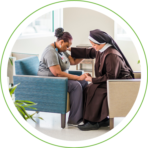 Nun and woman praying in the waiting room of a healthcare facility